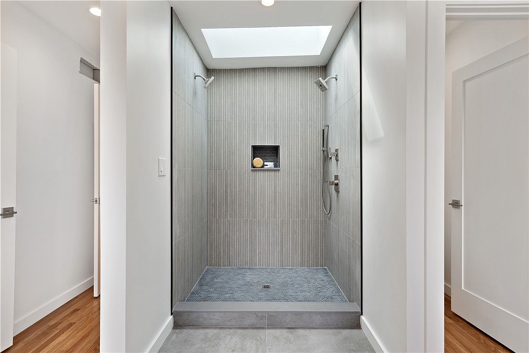 Walk-in shower with vertical gray tile and skylight in a Lawrenceville home