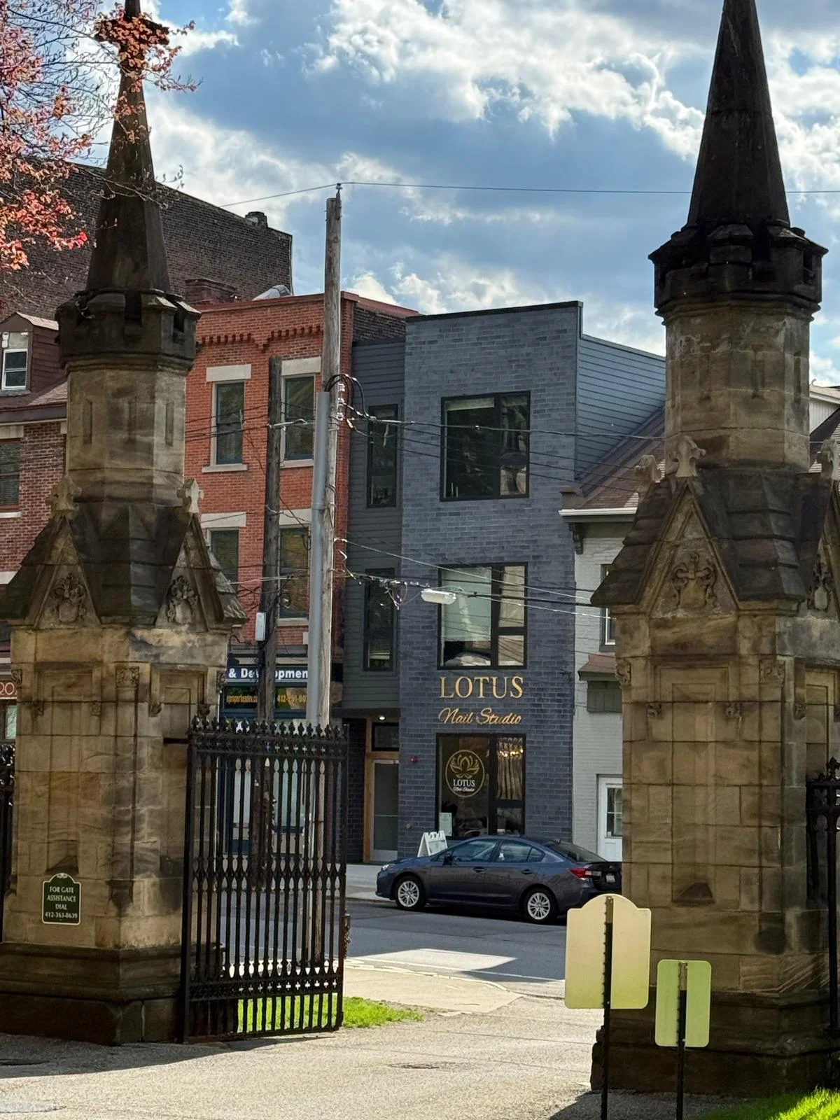 Storefront — framed through the historic church gates across Butler St