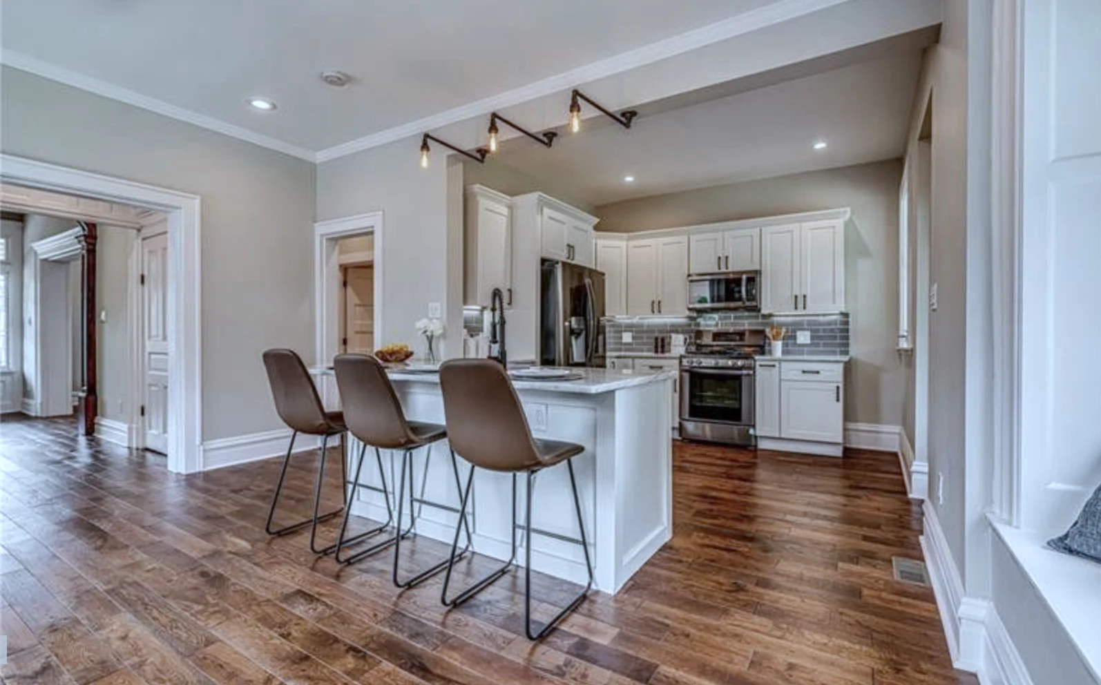 Kitchen &mdash; open to dining, marble subway-tile backsplash