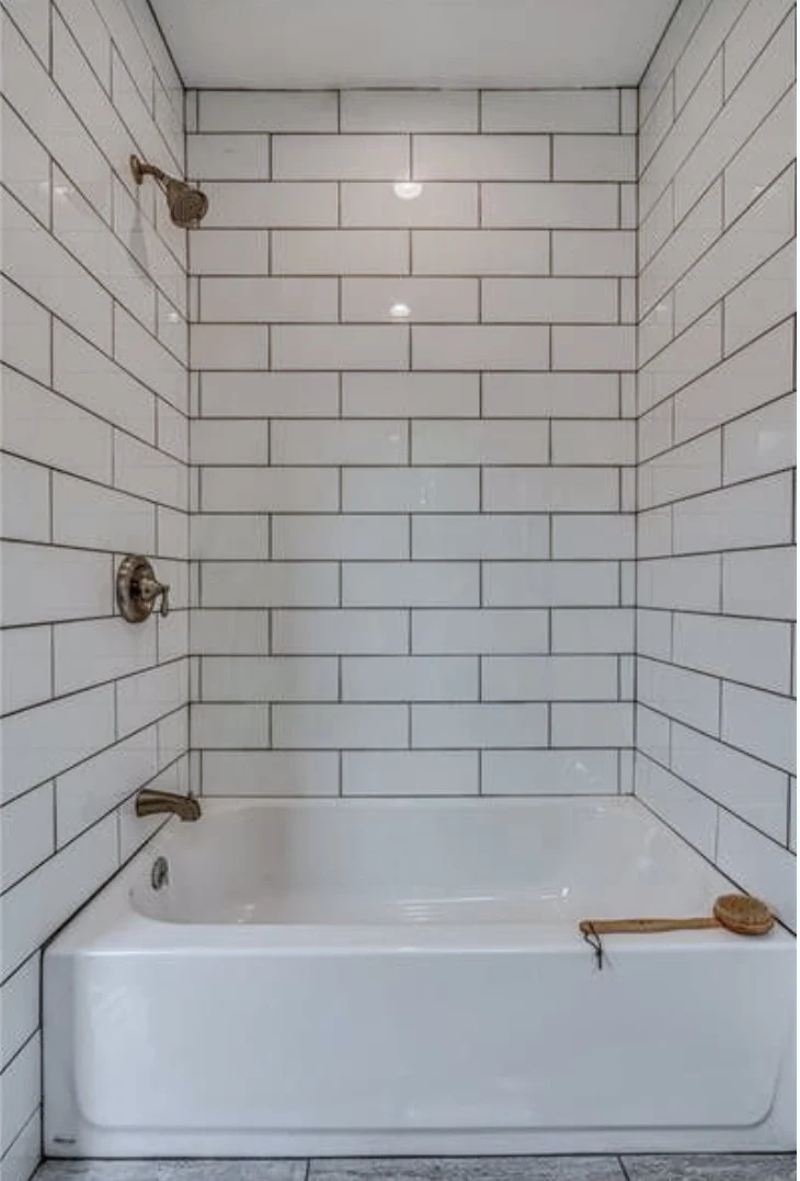 Hall bath &mdash; classic subway tile and polished-brass fixtures