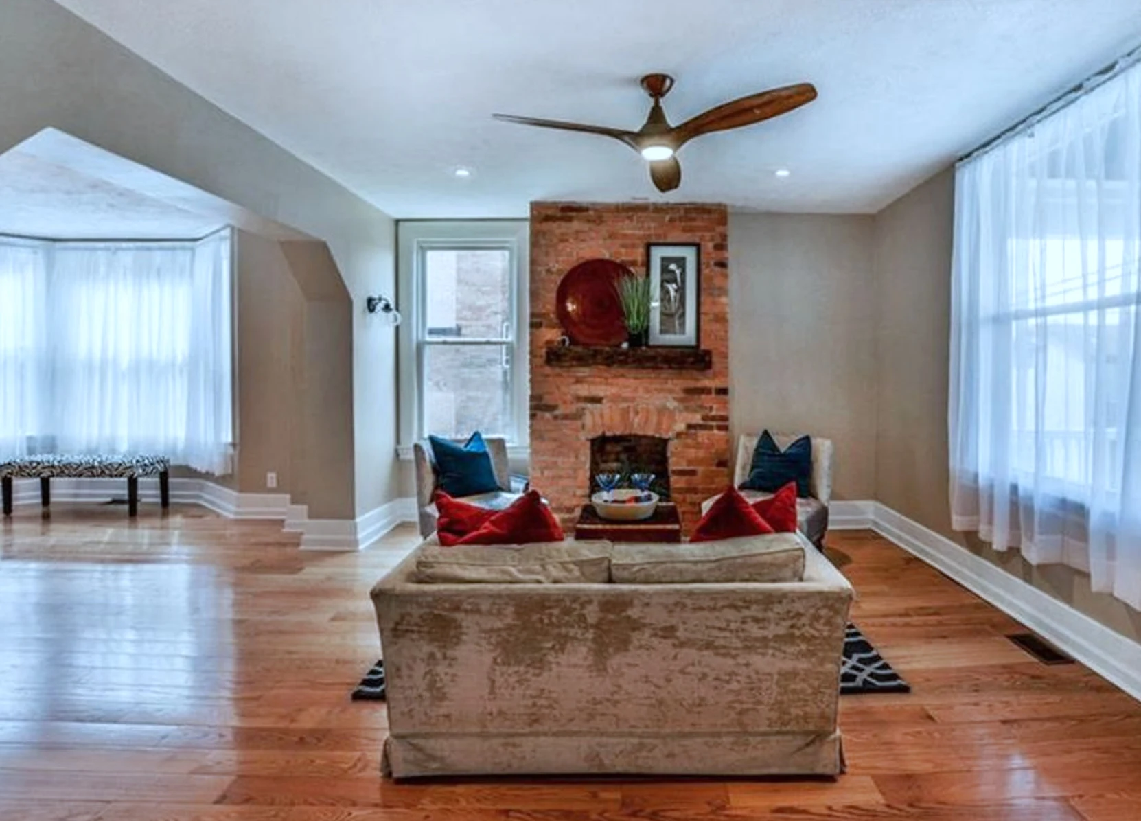 Living room &mdash; exposed-brick fireplace and refinished hardwood