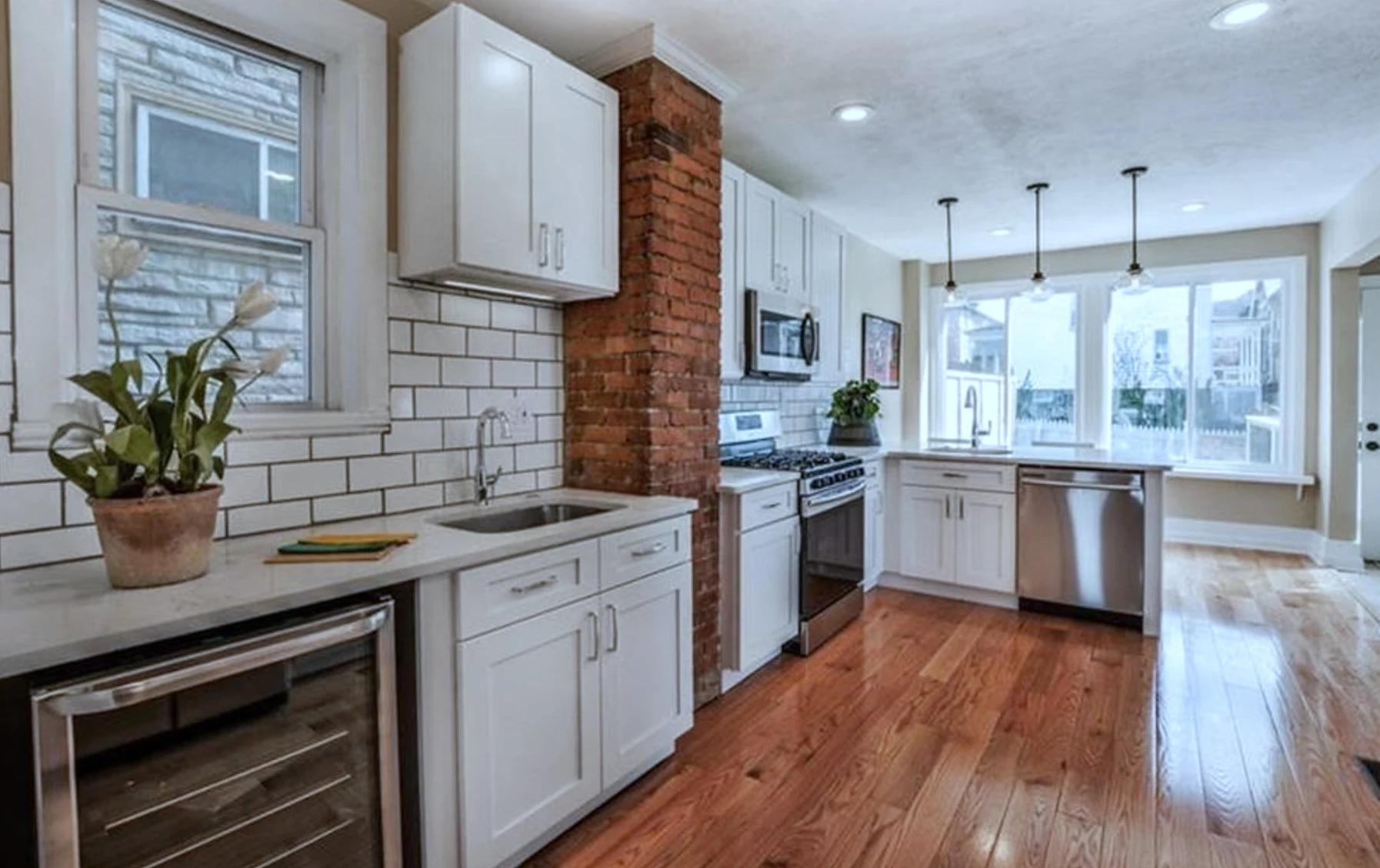 Kitchen &mdash; white subway tile and exposed-brick accent