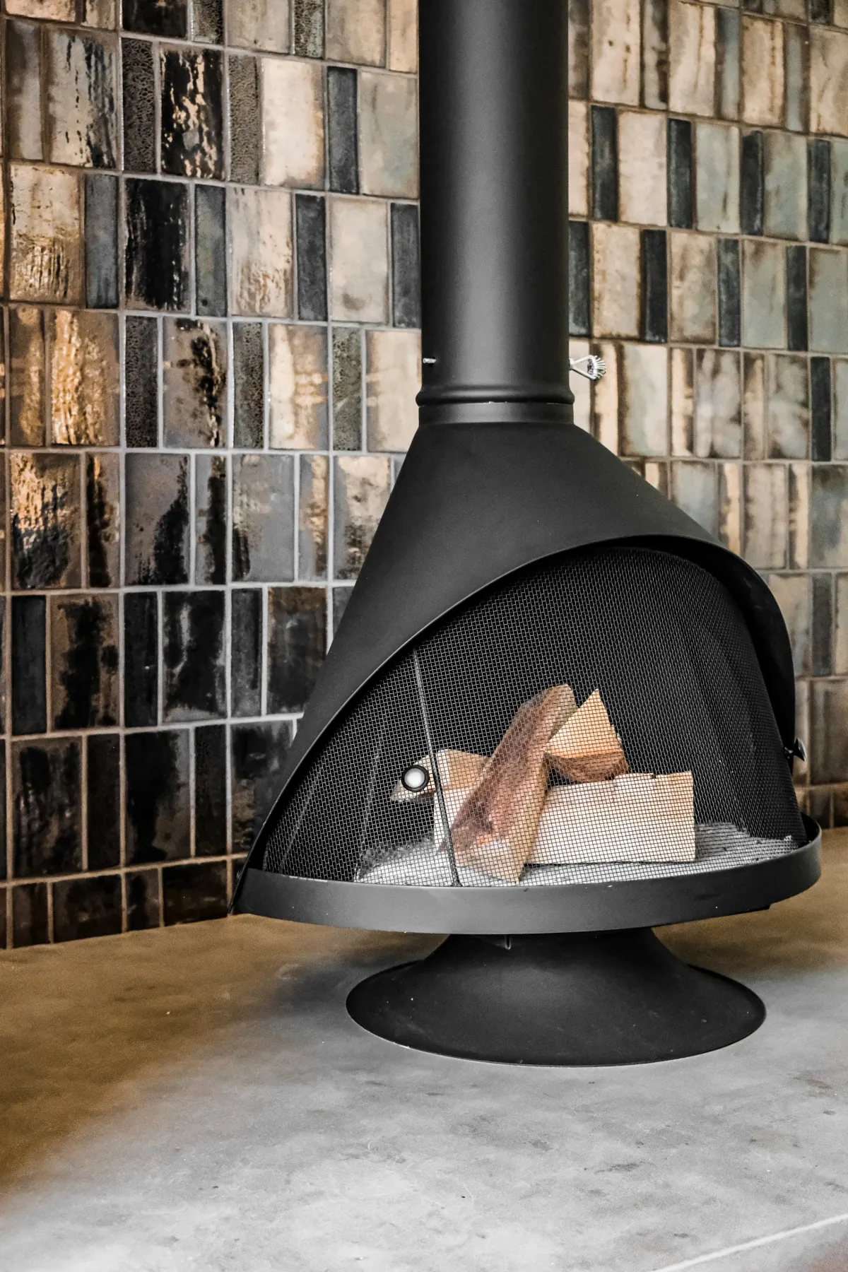 Suspended-hood Malm fireplace in front of a wall of hand-glazed tile