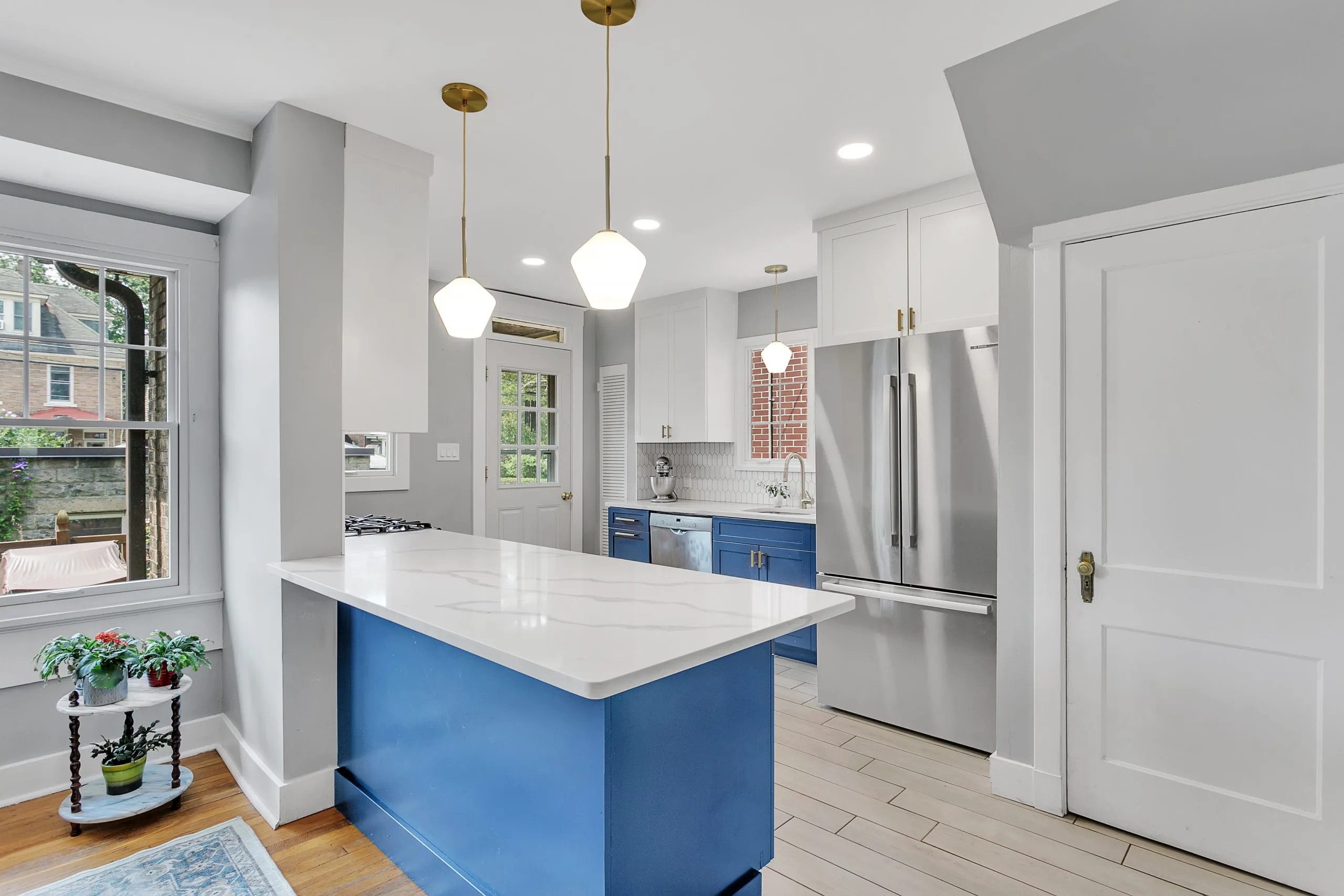 White kitchen with a blue island and glass pendants in Regent Square, Pittsburgh