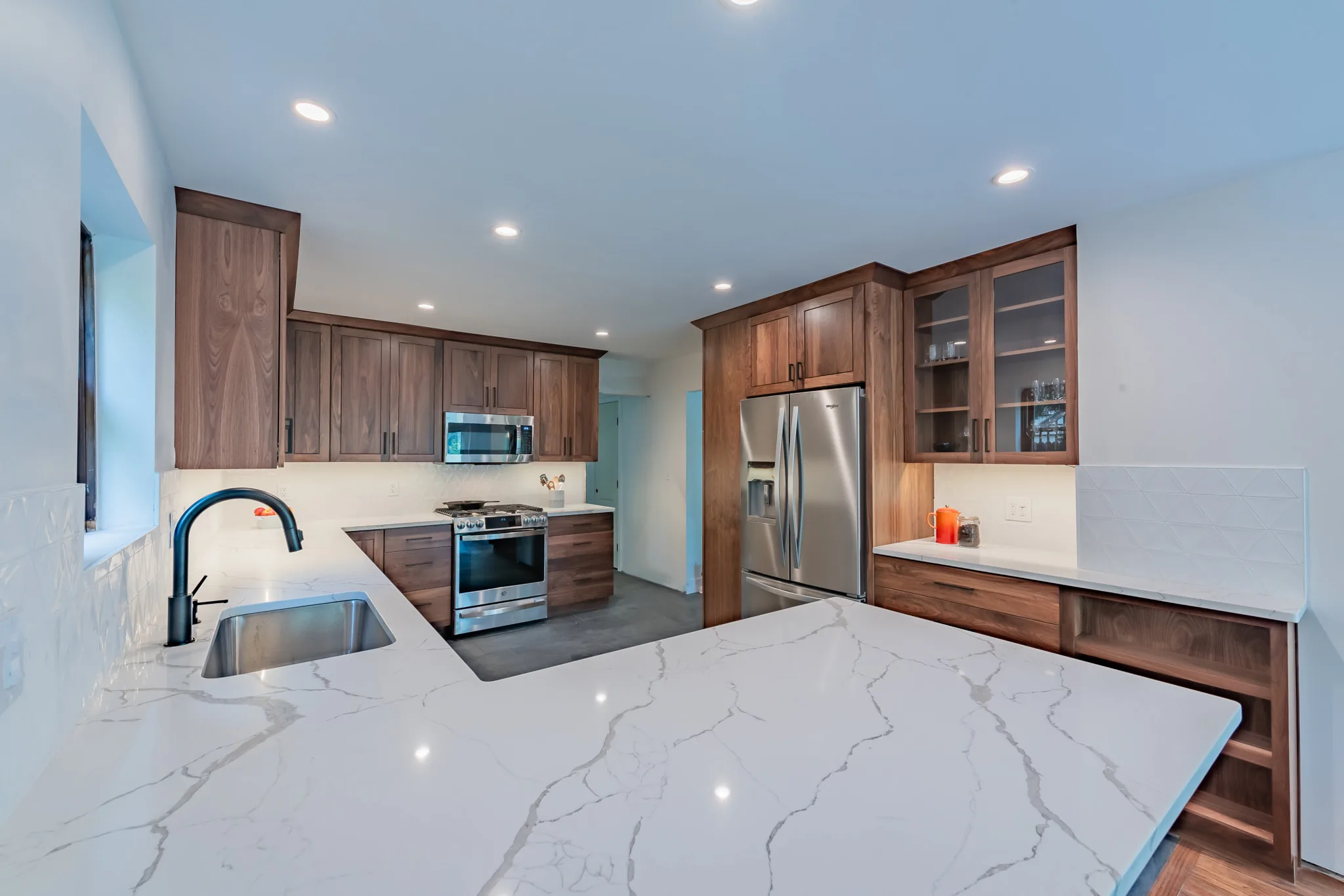 Modern walnut kitchen with a white quartz waterfall island in a Point Breeze, Pittsburgh home by Incline Homes