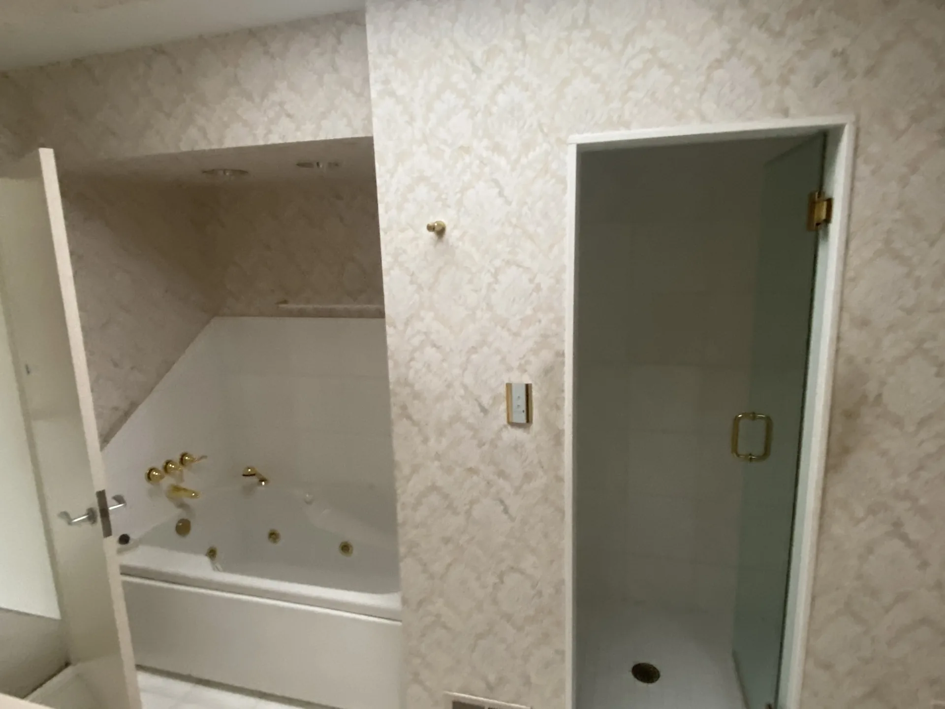 Dated Pittsburgh bathroom with wallpaper and an old jetted tub before remodeling