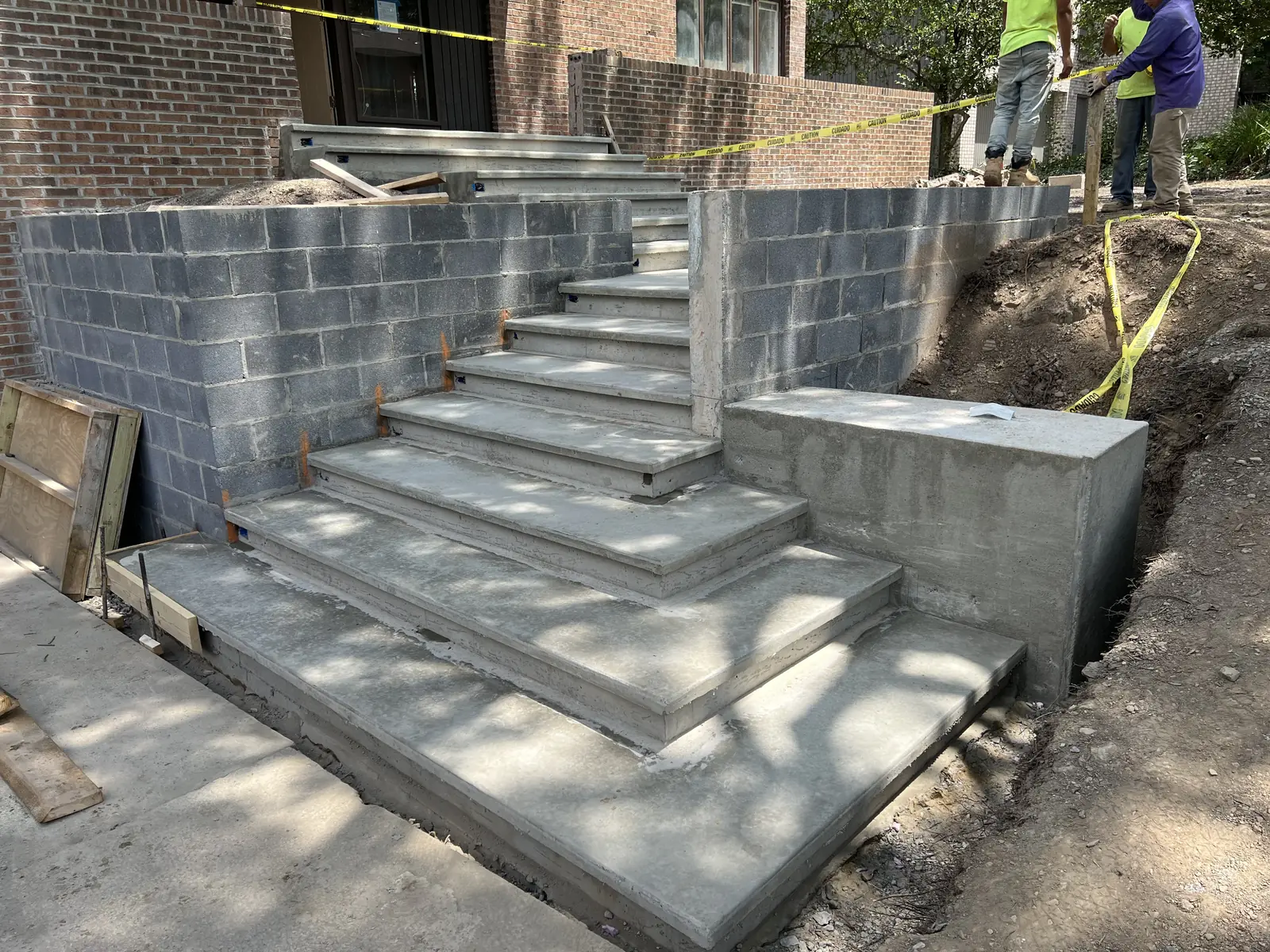 Finished poured concrete steps and landings between block retaining walls on a Pittsburgh hillside lot