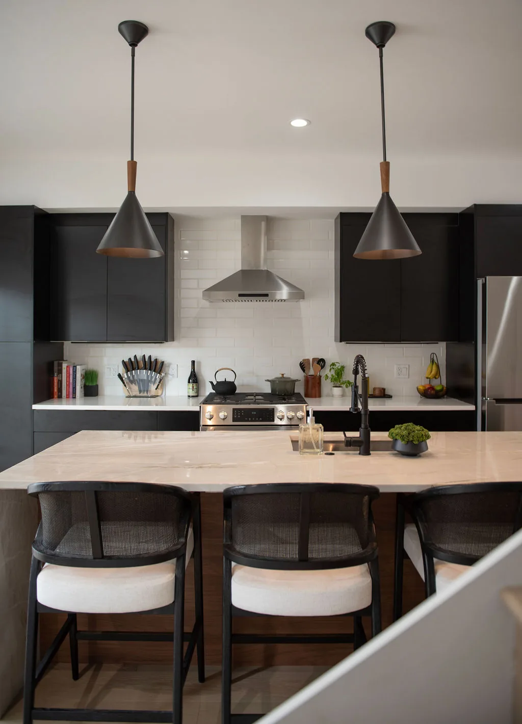 Custom kitchen with black cabinetry and a waterfall quartz island in a Pittsburgh custom home