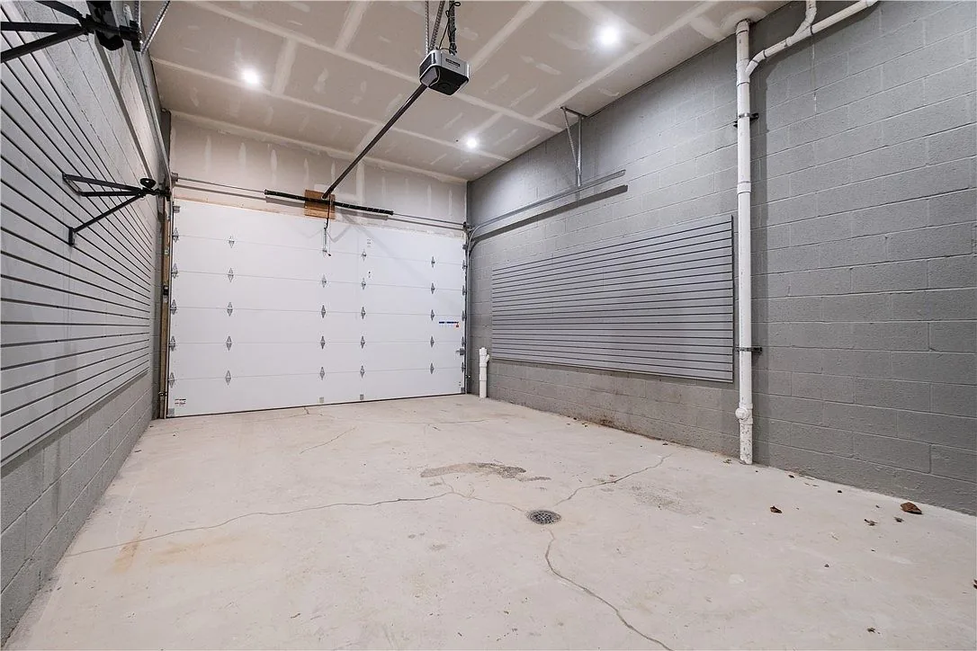 Finished interior of a Pittsburgh garage with drywalled ceiling, sealed concrete floor, and an installed overhead-door opener