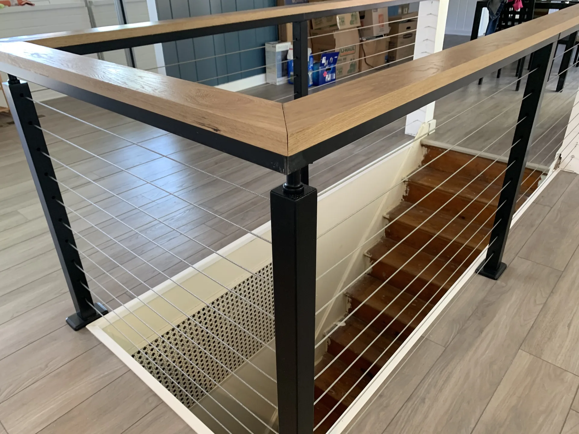 Cable-railing and oak-cap stair detail showing commercial-grade finish carpentry in Pittsburgh