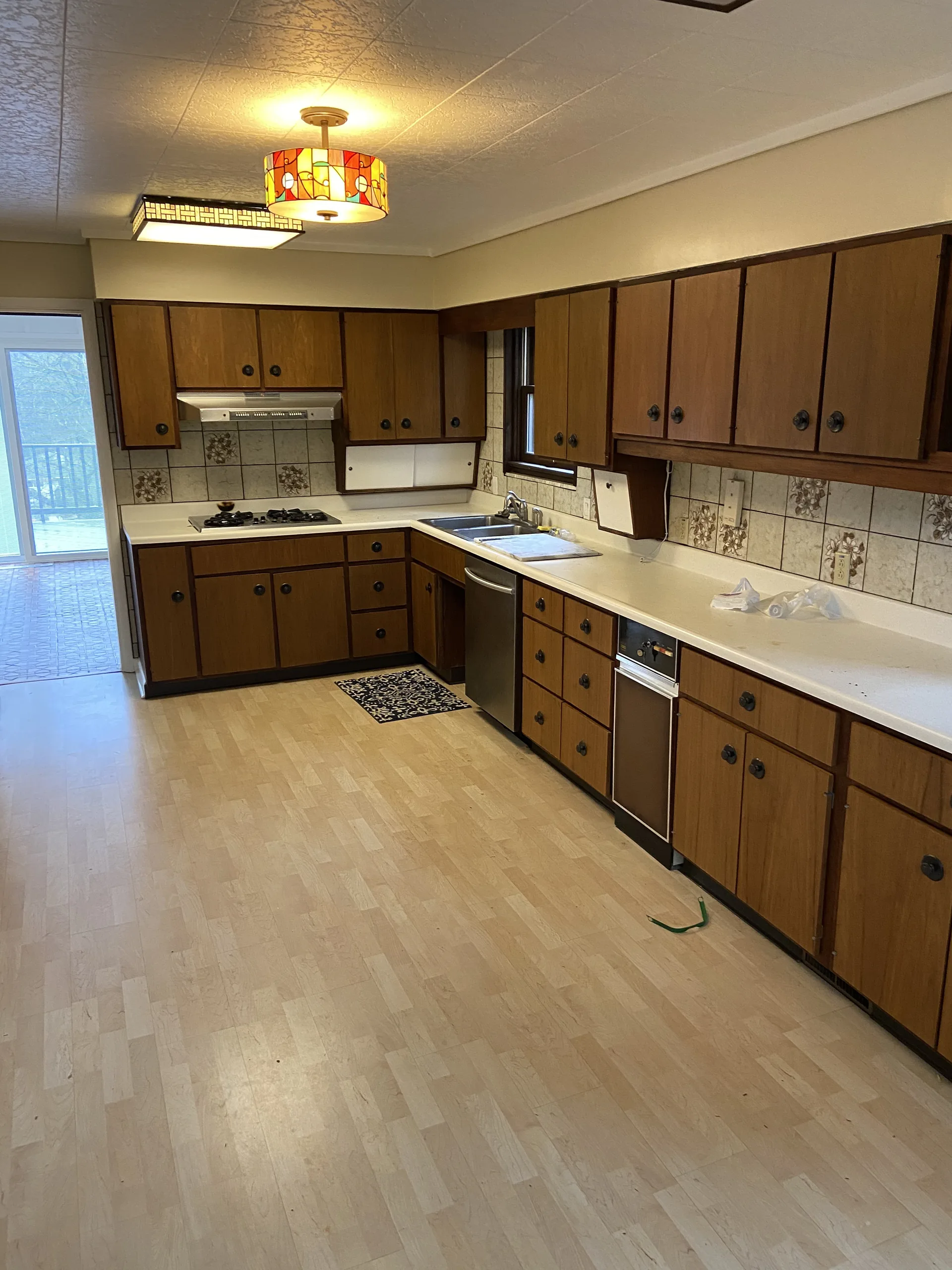 Dated oak kitchen with stained-glass light fixture before a Pittsburgh whole-home renovation
